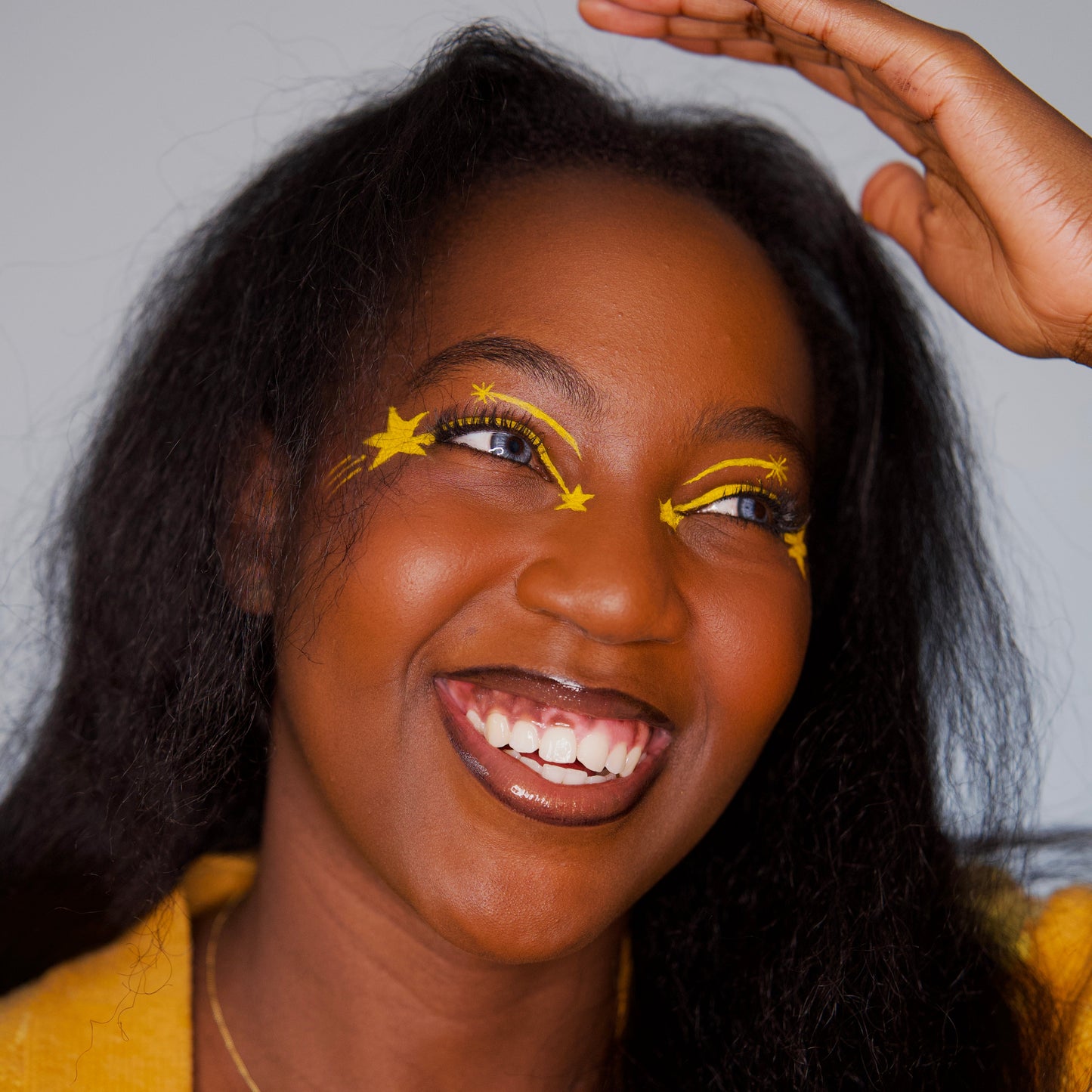 Bright Side Water Activated Liner | Vegan Eyeliner – Noma used for vibrant yellow star makeup on a smiling model.