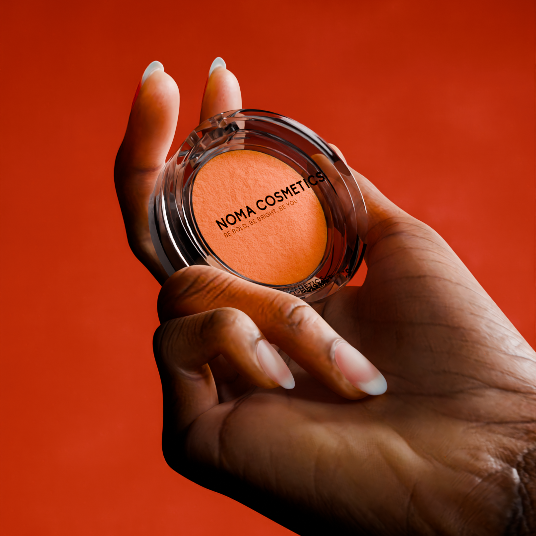 Tangerine Rush Water Activated Liner | Vegan Eyeliner – Noma in a clear pot held by a hand against a vibrant orange background.